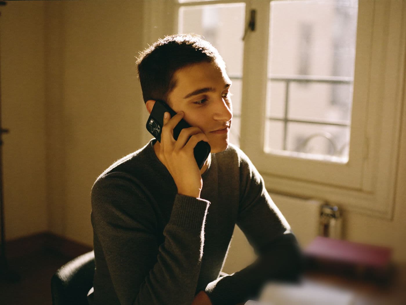 Un mentor Majorant au téléphone avec une famille, dans un bureau parisien