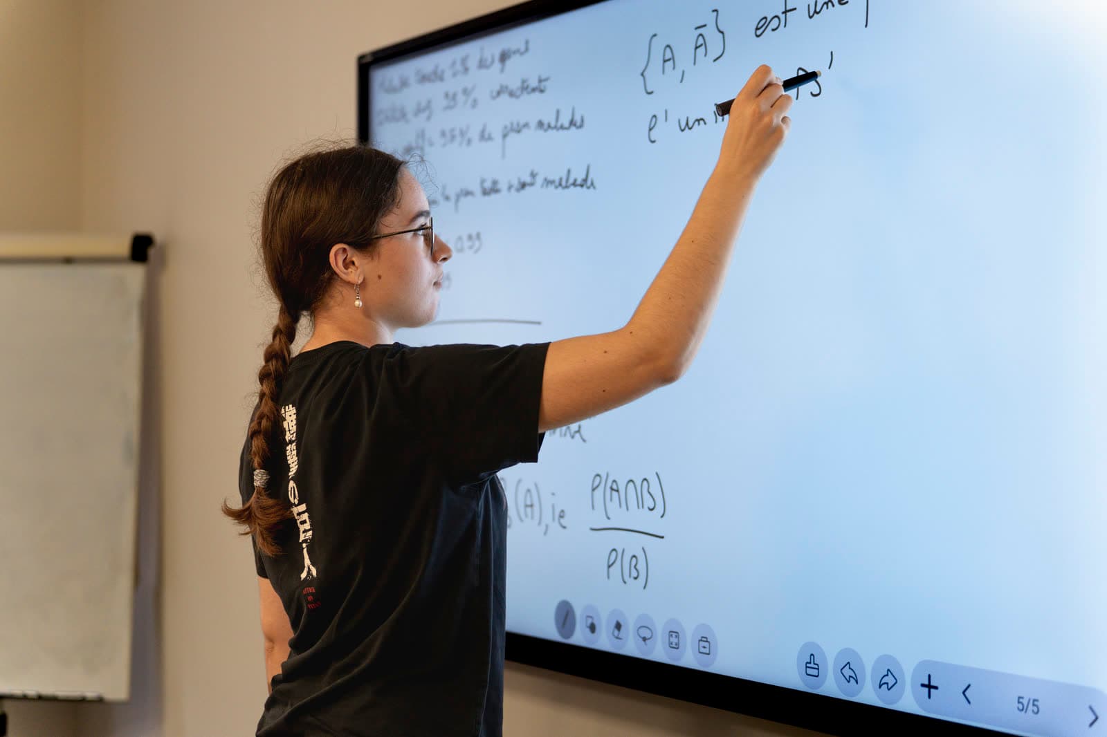 Une élève de prépa travaille une démonstration de probabilités au tableau
